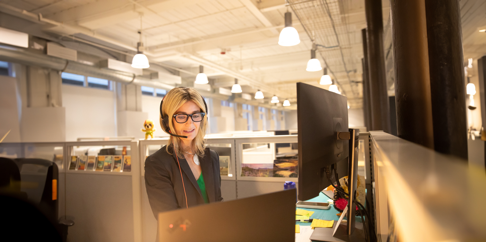 una mujer con auriculares y mirando un ordenador