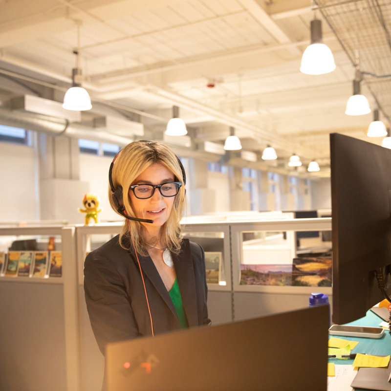 a woman wearing a headset and looking at a computer