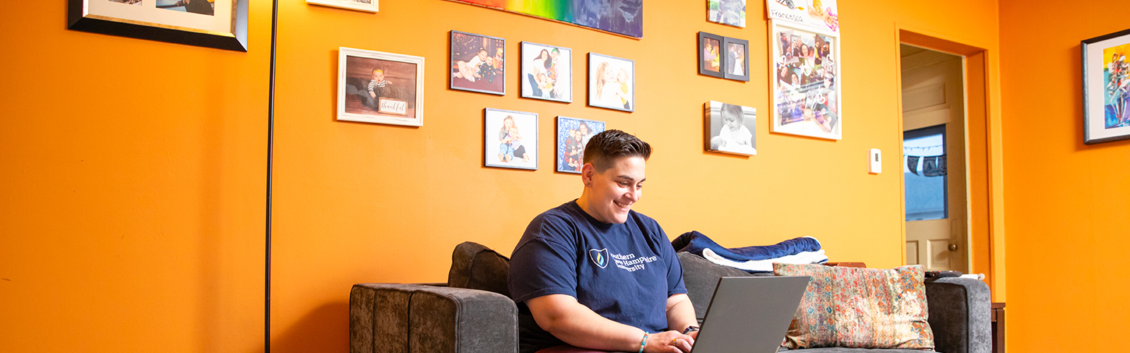 a man sitting on a couch using a laptop
