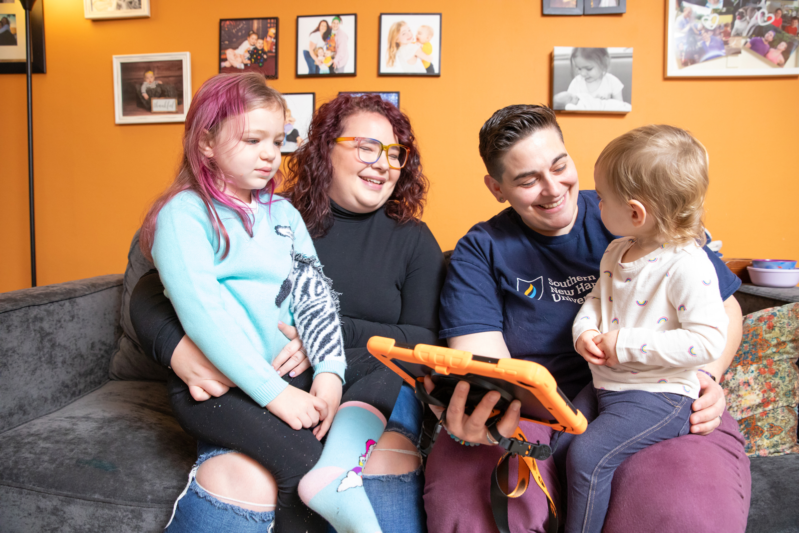 a group of people sitting on a couch with a tablet