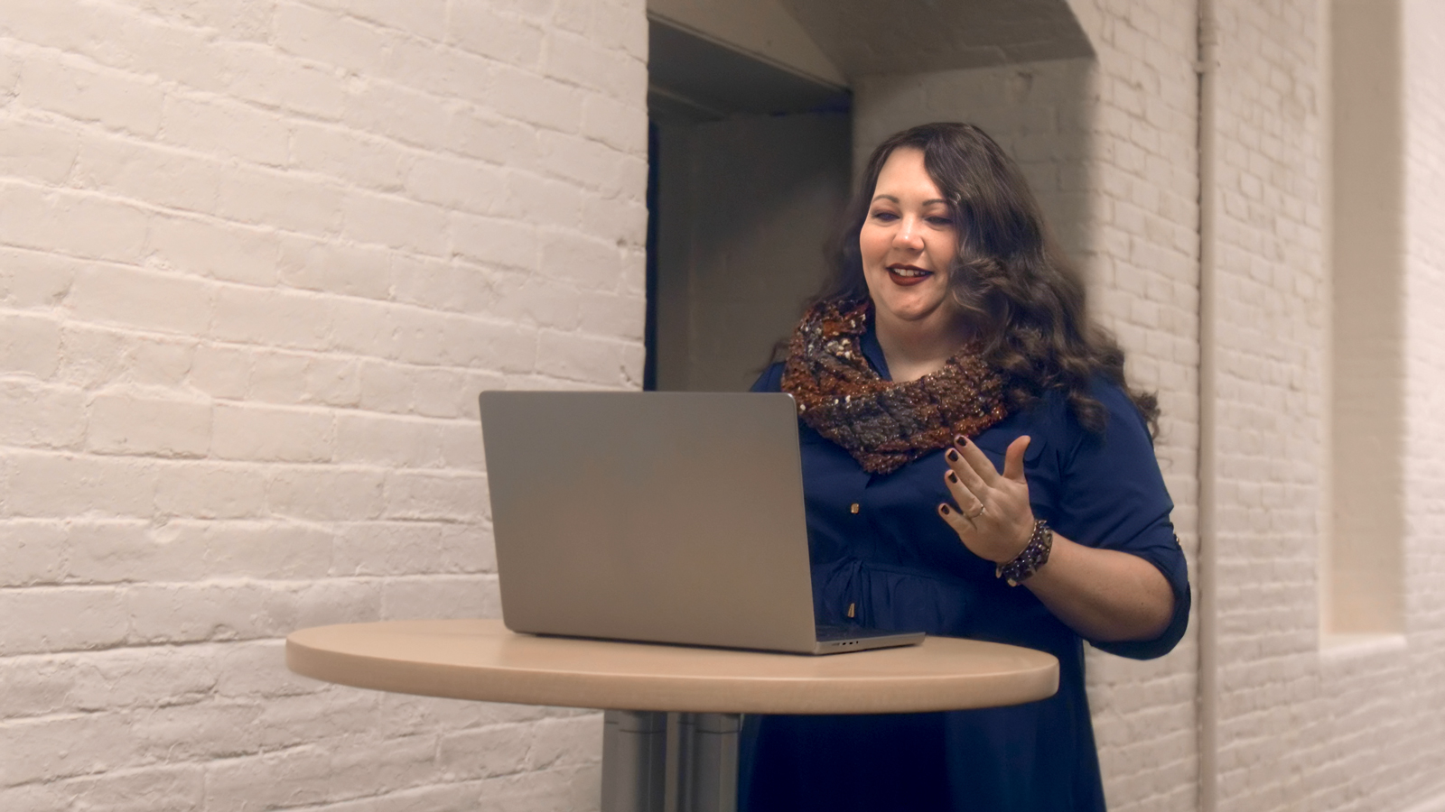 a woman standing in front of a laptop