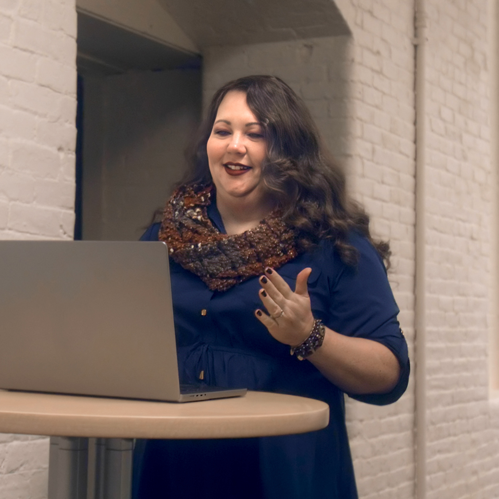 a woman standing in front of a laptop