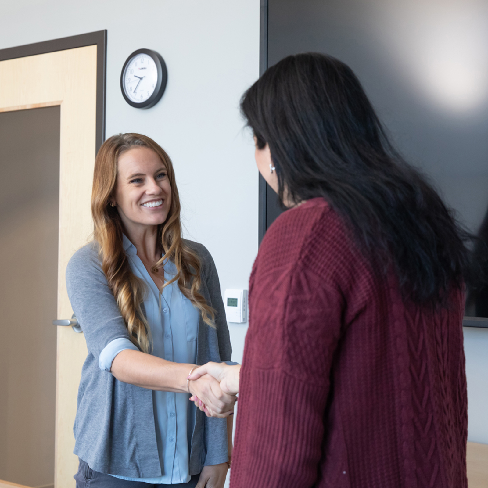a woman shaking hands with another woman