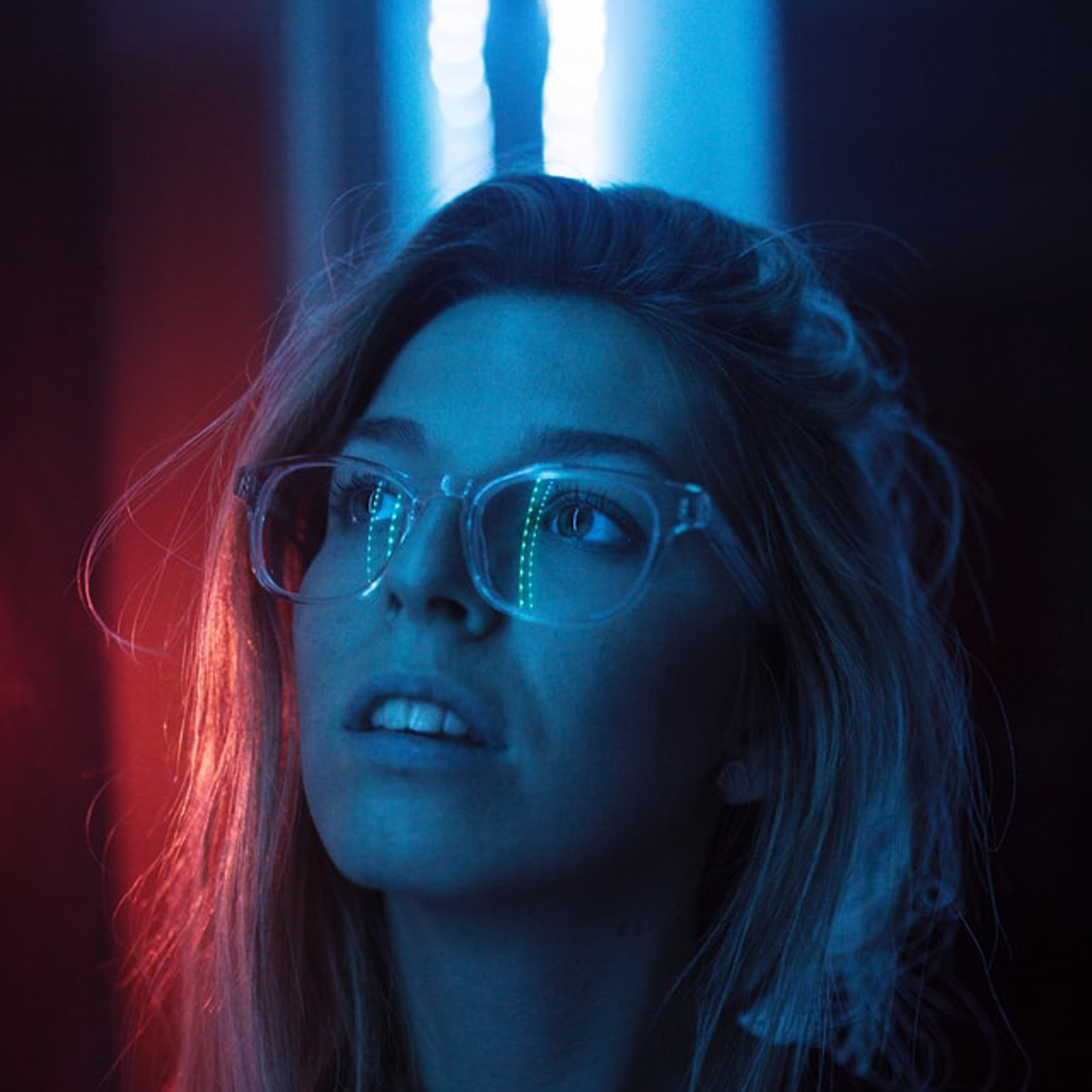 Una mujer mirando hacia arriba con una luz azul y roja