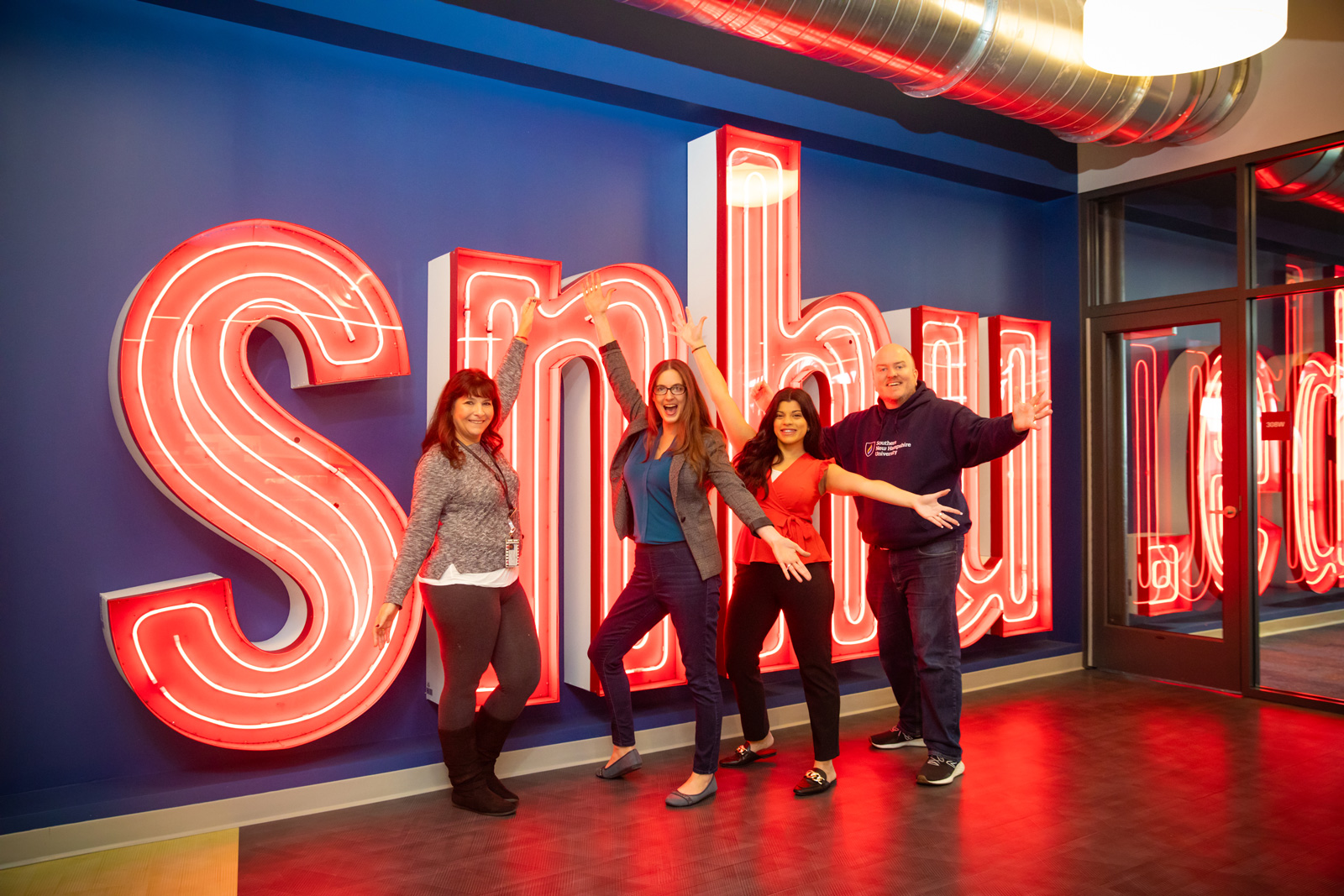 a group of people posing in front of a large sign