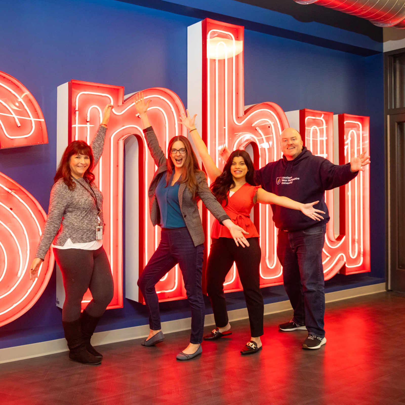 a group of people posing in front of a large sign