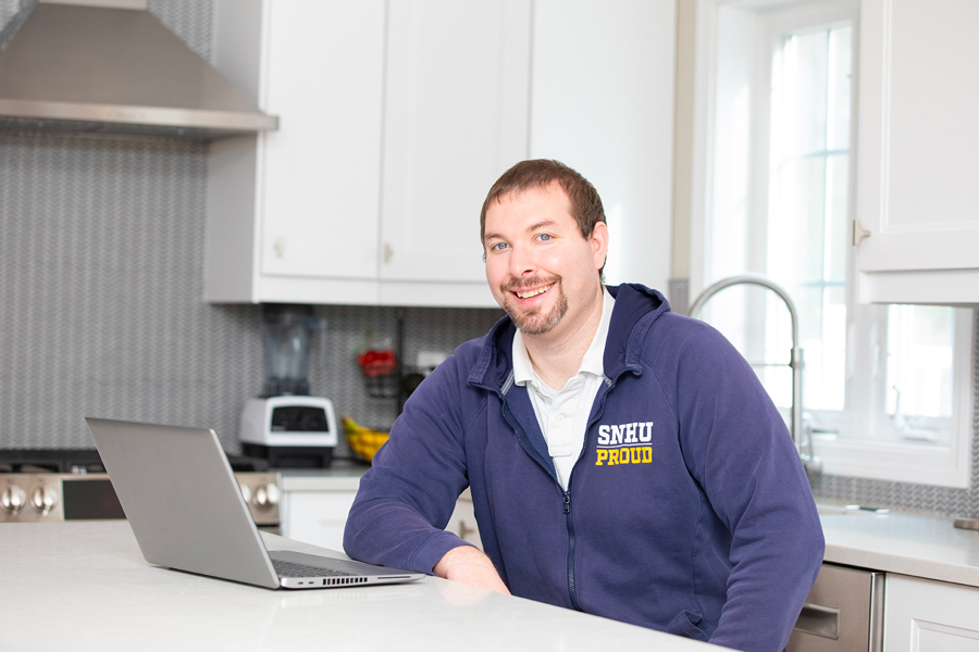 a man sitting at a table with a laptop