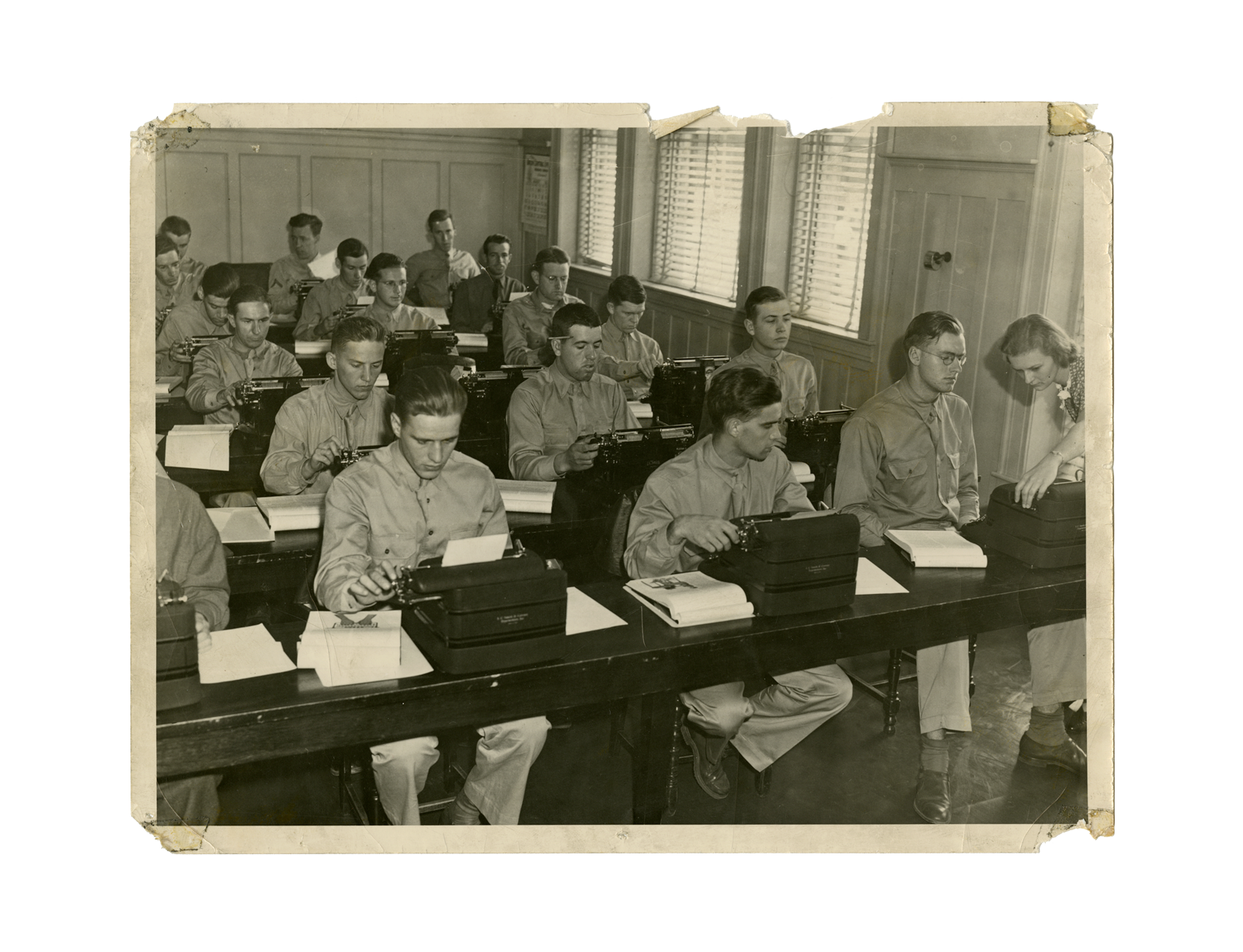 a group of men sitting at desks with typewriters