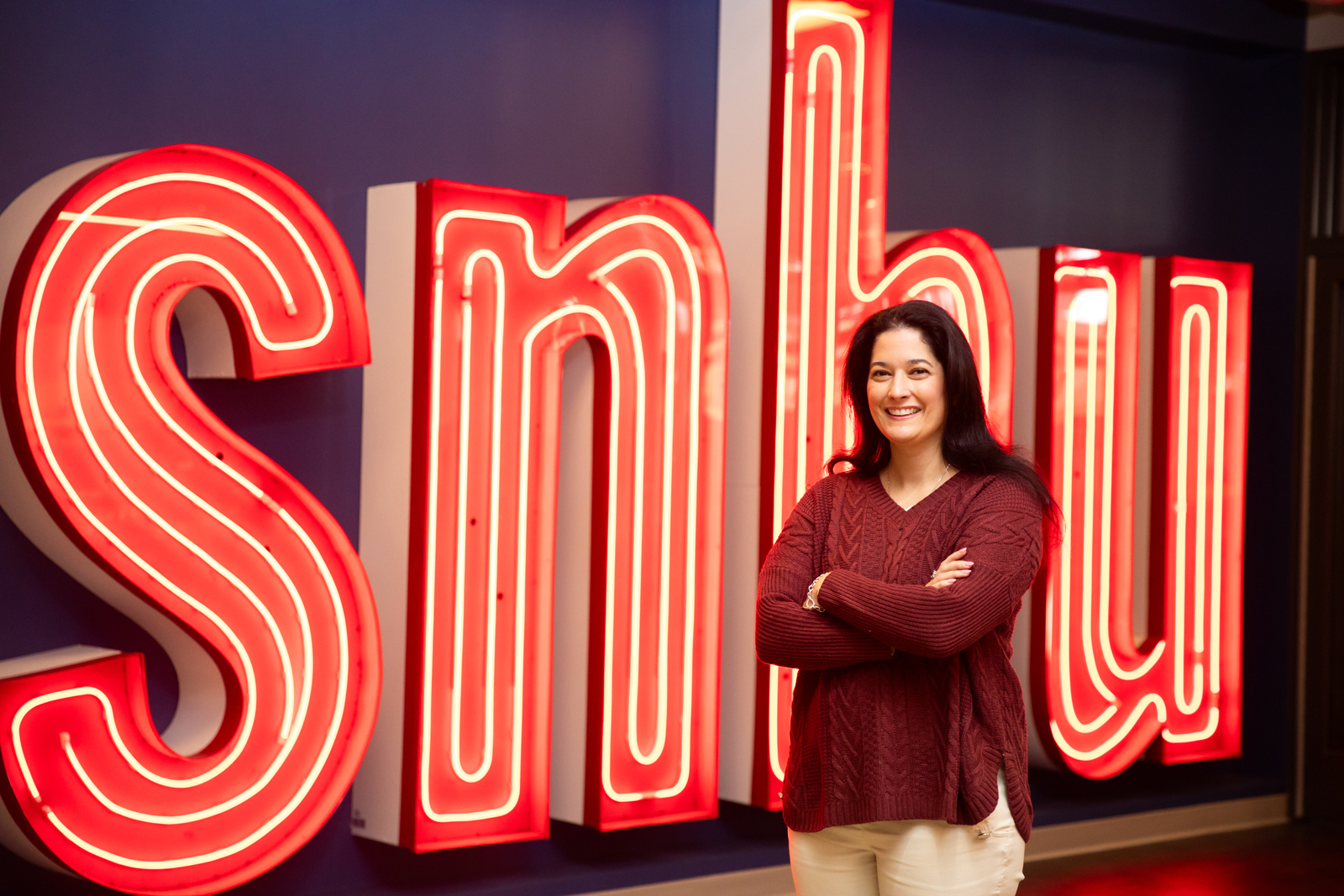 Una mujer de pie frente a un letrero