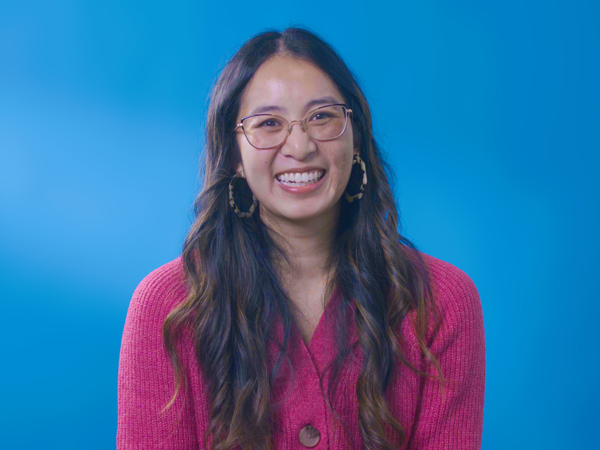 a woman wearing glasses and a pink sweater