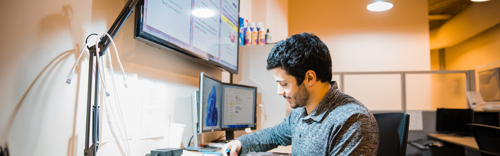 a man sitting at a desk working on a computer