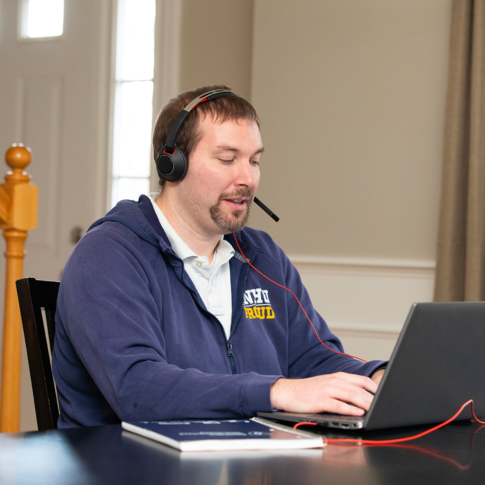 a man wearing headphones and using a laptop