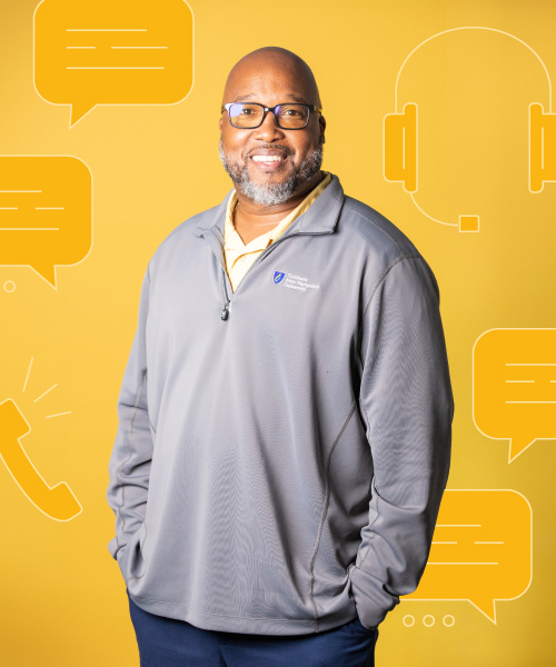 a man in glasses and a grey jacket