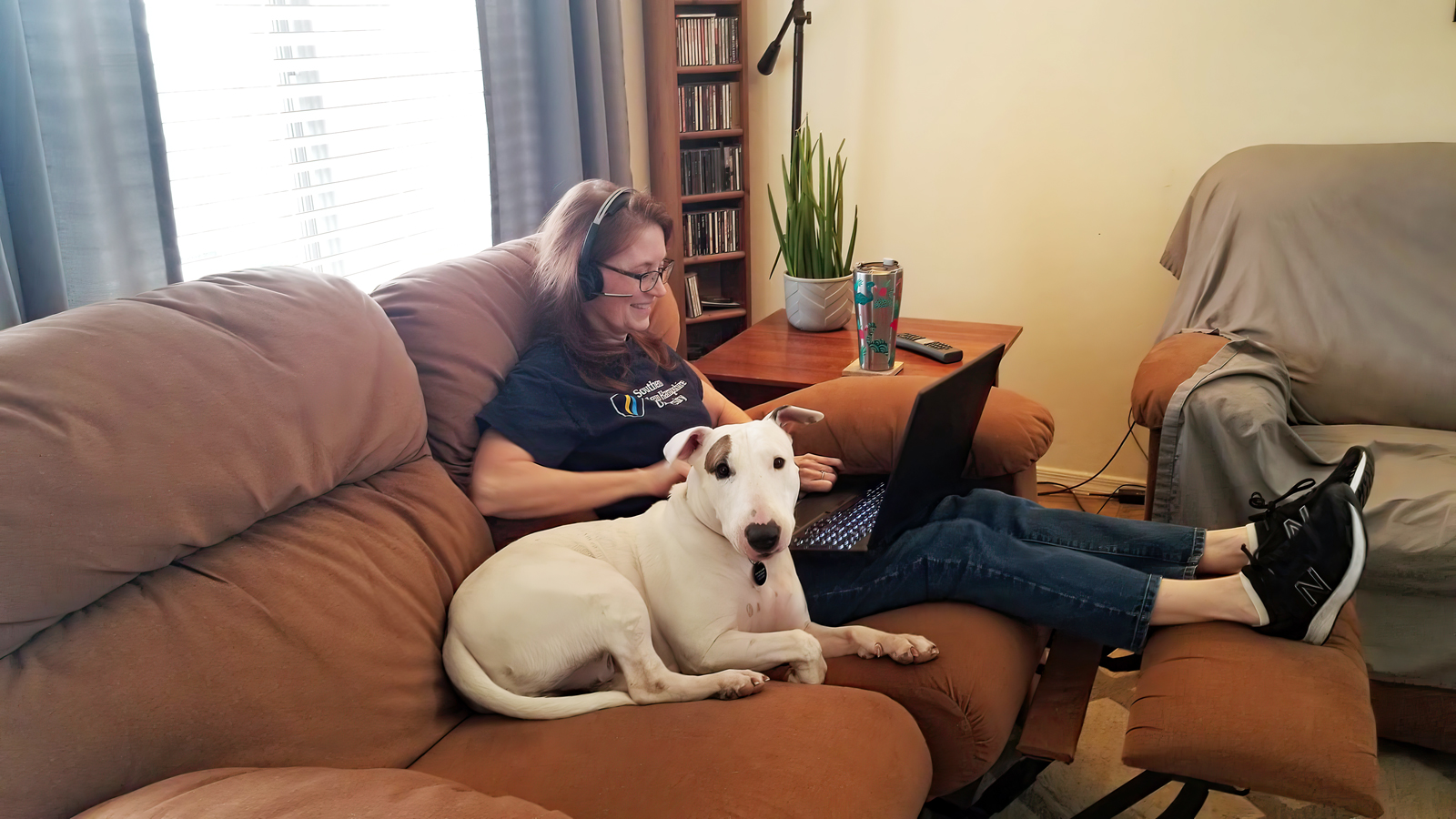 a woman sitting on a couch with a dog