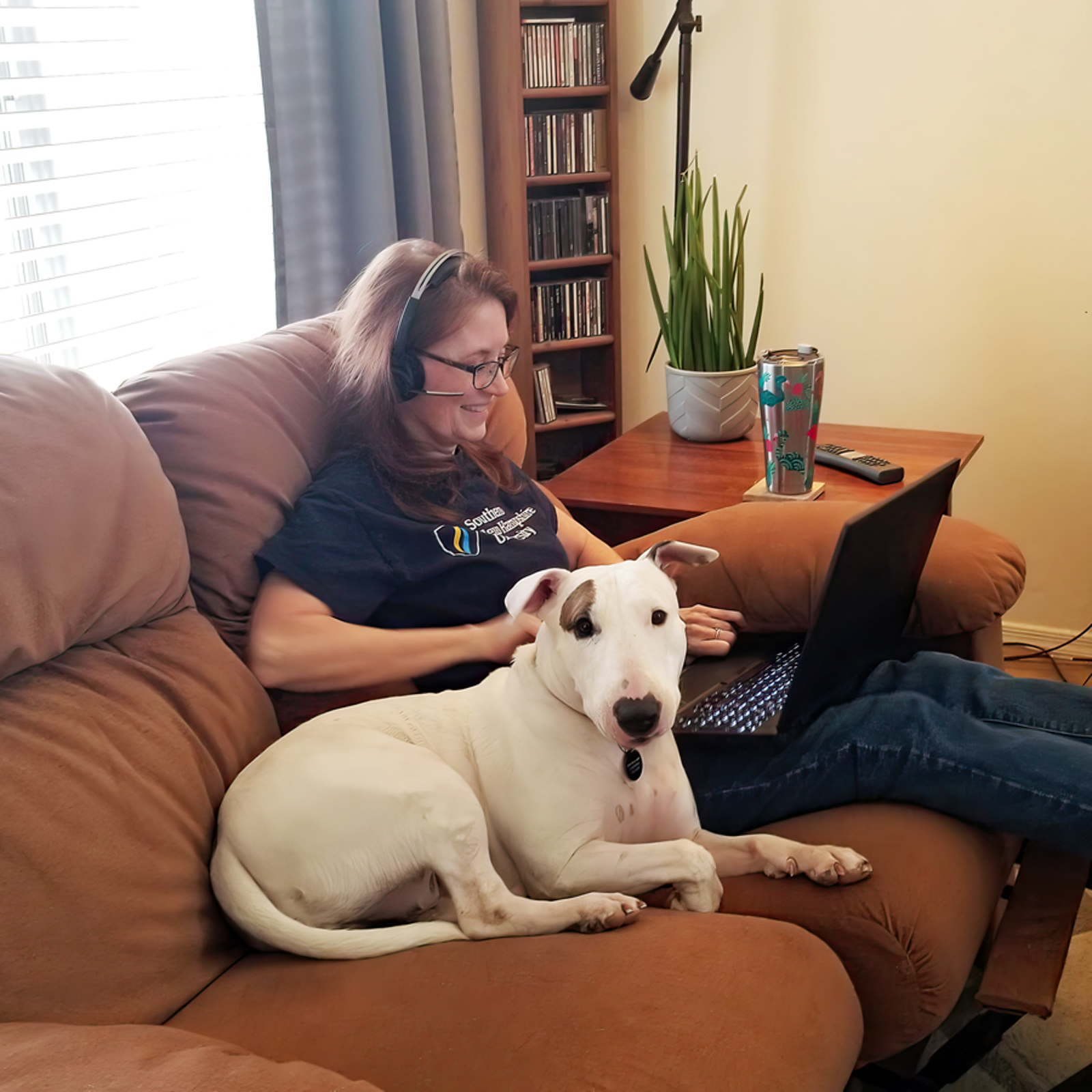 a woman sitting on a couch with a dog