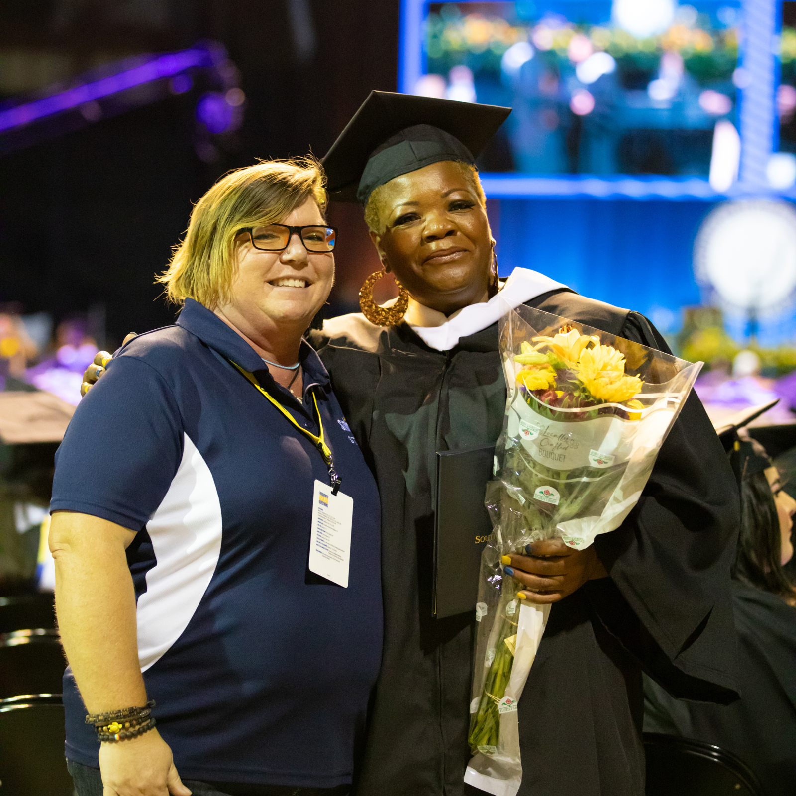 a woman in a graduation cap and gown with a woman in a graduation cap and gown