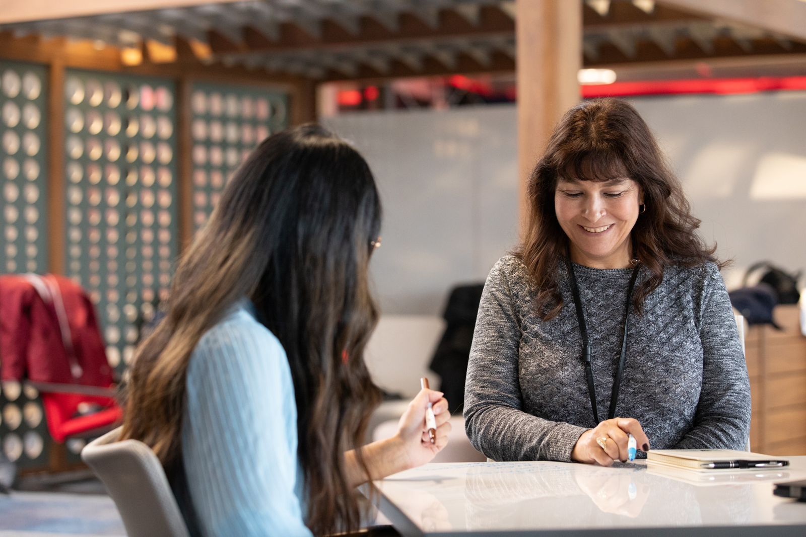 a woman sitting at a table with another woman