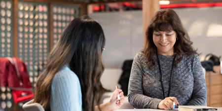 a woman sitting at a table with another woman