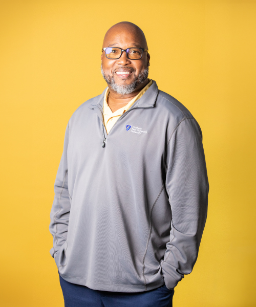 a man in glasses and a grey jacket